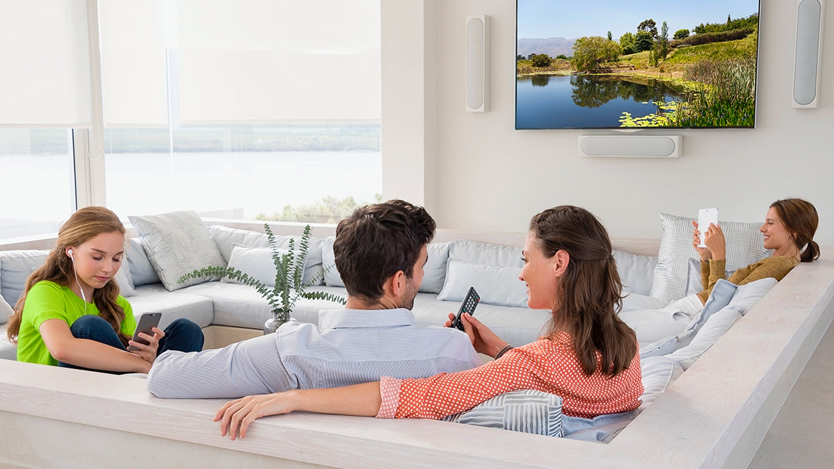 Family using phones and tablets on couch